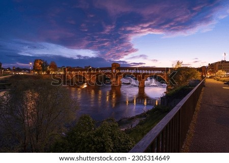 Ponte Coperto (covered bridge) over Ticino river in Pavia at blue hour, Lombardy, italy.