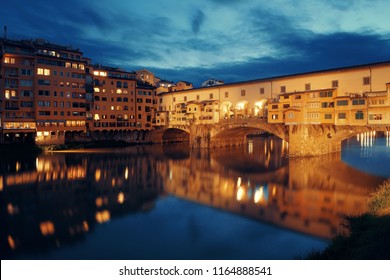 Ponte Vecchio over Arno River at night in Florence Italy.