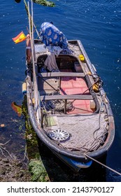 PONTESAMPAIO, SPAIN - SEPTEMBER 21, 2021: Small artisanal fishing boat anchored at the village pier, with a car hubcap on its deck.