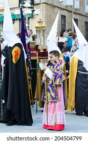 Pontevedra, SPAIN - APRIL 17, 2014: A Boy Dressed Acolyte Wait Between Hooded, To March In The Procession Of Holy Week.