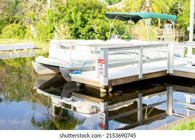 Pontoon boat at private dock no wake zone sign