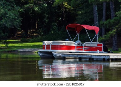 Pontoon Boat At Private Dock On Lake.