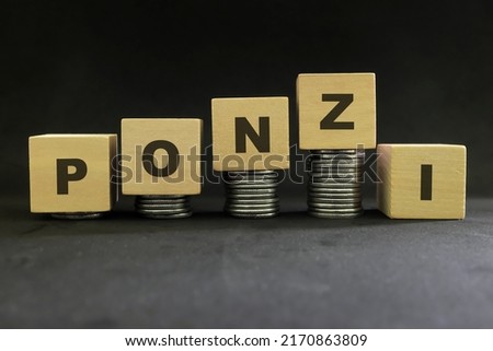 Ponzi scheme concept. Stack of coins on wooden blocks with word ponzi in dark black background.