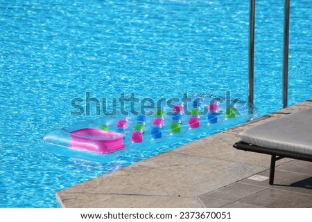 Pool air mattress. Colorful mattress floating on blue water.