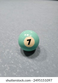 Pool balls on gray table sport game set known as eight ball pool. Number seven.