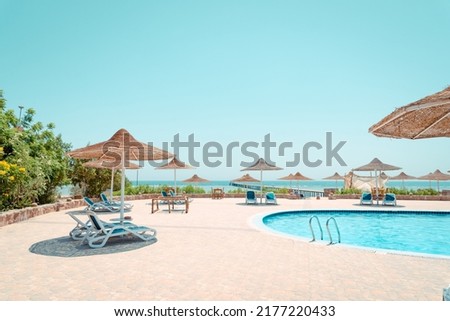 pool with beach umbrella and chaise lounge