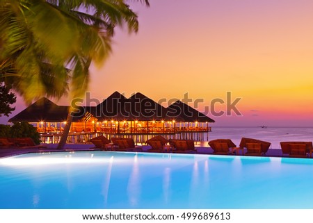 Pool and cafe on tropical Maldives island - nature travel background