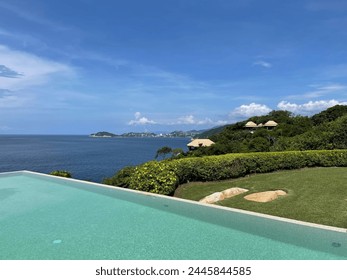 Pool and cliffside villas at a tropical resort - Powered by Shutterstock