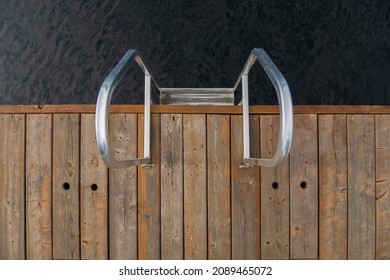 Pool ladder on a cottage wooden pier in a lake in Muskoka, Ontario Canada