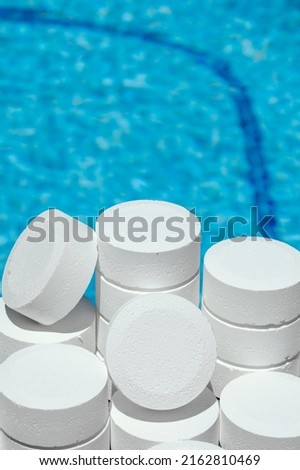 Pool maintenance with chlorine. Swimming pool cleaning with chlorine tablets to prepare the bath glass tablets for swimming pools. chlorine tablets. white chlorine in round tablets