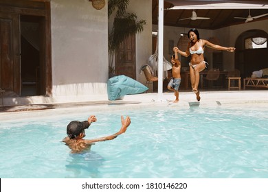 Pool. Mother And Son Jumping In Water From Poolside. Father Getting Ready To Catch Kid And Mom. Family Enjoying Vacation At Tropical Resort. Summer Activity As Lifestyle. - Powered by Shutterstock