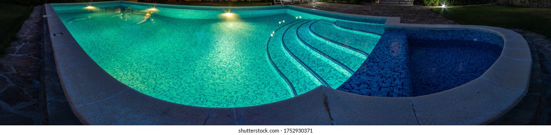 Pool at night with pure blue water background. Top view of swimming pool and floor texture Panorama of pool bottom with tile pattern and transparent water Summer travel and vacation background concept