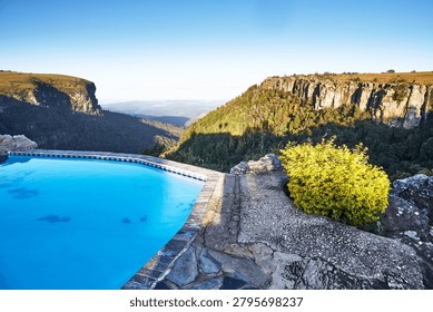 A pool on a cliff overlooking the lower part of the reserve near the God's Window viewpoint in the Drakensberg Mountains during sunrise