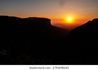 A pool on a cliff overlooking the lower part of the reserve near the God's Window viewpoint in the Drakensberg Mountains during sunrise