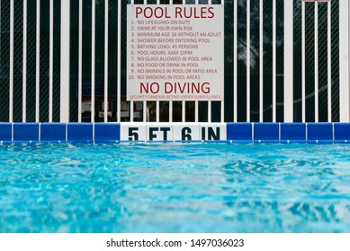 Pool Rules Sign At The Deep End Of A Swimming Pool With Tiles Indicating The Water Depth