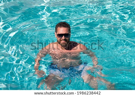 Pool spa resort. Summertime vacation at pool. Summer weekend. Handsome man in swimmingpool.