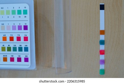 Pool Test Strip And A Comparison Chart On A Wooden Surface. Pool Chemistry Concept.