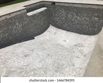 A pool that has been drained and demolished, so that it can be resurfaced.