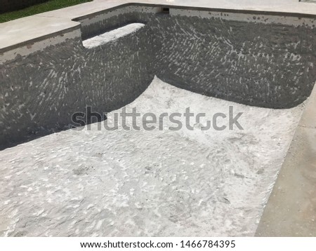 A pool that has been drained and demolished, so that it can be resurfaced.