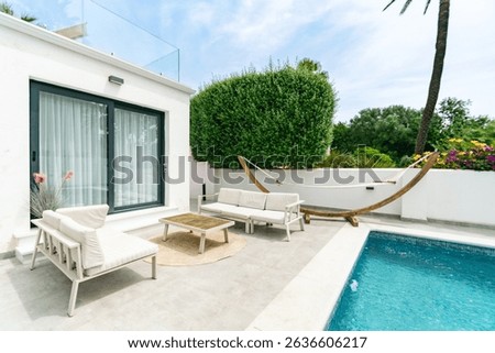 a poolside image of outdoor sofas and a hammock in a luxury mediterranean real estate 