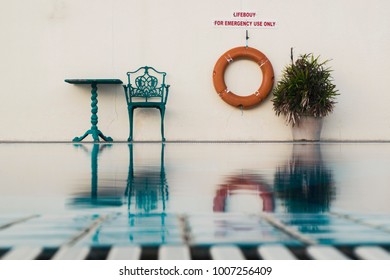 Poolside View With Single Chair And Table. 