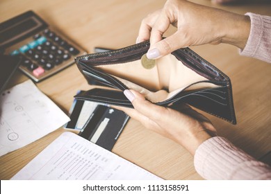 poor Asian woman hand open empty purse with only one coin left bankrupt broke after credit card payday