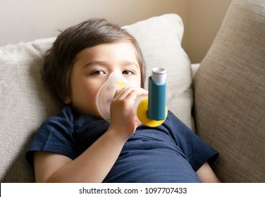 Poor Boy Have A Problem With Chest Coughing Holding Inhaler Mask, Child Using The Volumtic For Breathing Treatment, Kid Having Asthma Allergy Using The Asthma Inhaler, Healthcare And Medicine Concept