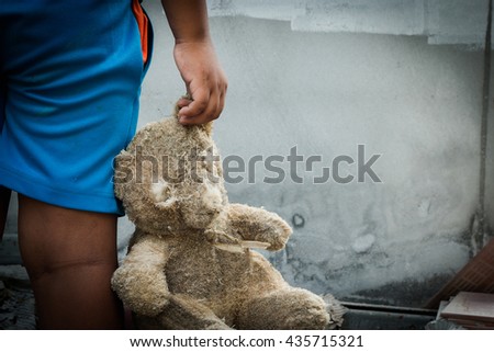 Poor child holding a teddy bear