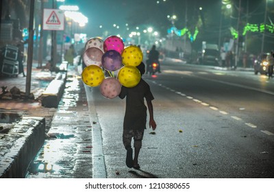 A poor child selling beautiful and colorful balloons on the street of Hyderabad to earn his living.