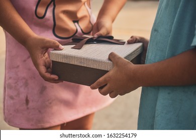 Poor Children Are Accepting Gifts,Girl Giving Gift Box To Boy