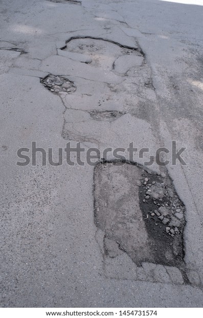 Poor condition of\
the road surface. Summer season. Hole in the asphalt, risk of\
movement by car, bad asphalt, dangerous road, potholes in asphalt.\
July 18, 2019.\
Kiev,Ukraine