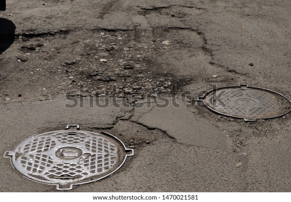 Poor condition of\
the road surface. Summer season. Hole in the asphalt, risk of\
movement by car, bad asphalt, dangerous road, potholes in asphalt.\
August 4, 2019.\
Kiev,Ukraine