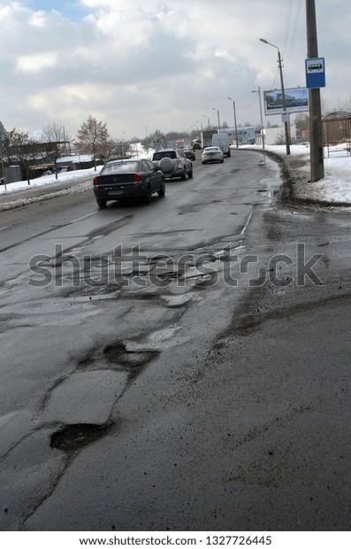 Poor condition of\
the road surface. Winter season. Hole in the asphalt, risk of\
movement by car, bad asphalt, dangerous road, potholes in asphalt.\
February 4, 2019.\
Kiev,Ukraine