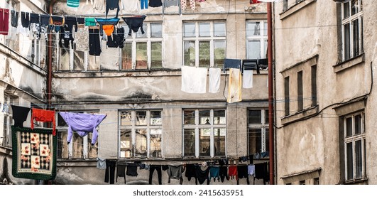 Poor district. Washed clothes drying outside of an old house. Poor district, houses of a poor district. Clothes hanging to dry on a clothes-line. Laundry dryings on the rope.