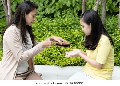 Poor family of single mother and teen daughter having no money, struggling with economic crisis, unemployment, inflation with empty purse - Shutterstock ID 2258089321