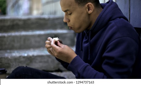 Poor Homeless Boy Eating Remains Of Food Found On Street, Cruel Reality, Poverty