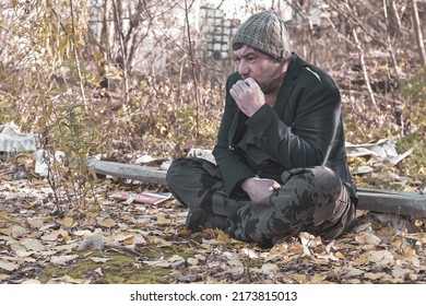 a poor homeless man with dirty hands smokes a cigarette in modern society. Economic recession, unemployment, poverty, hunger, pension, global crisis, the concept of the problem of inequality.
