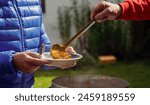 Poor and homeless people are served a daily meal at this centre in a western country. The meal is vegetarian and served from a large aluminium pot