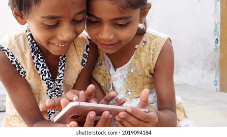 Poor Indian siblings playing with a phone for the first time