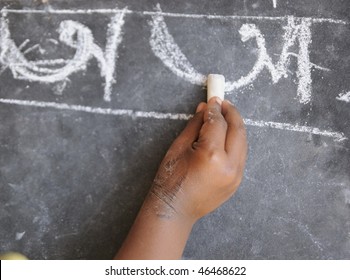 A Poor Kid In India Learning To Write Alphabets.