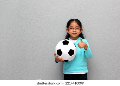 
Poor Latino 4-year-old gril plays with a soccer ball very excited that she is going to see the World Cup in poverty - Powered by Shutterstock