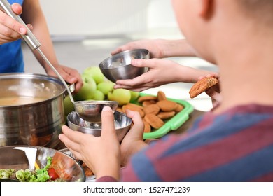 Poor Little Children Receiving Food From Volunteer In Charity Centre, Closeup