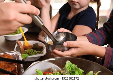 Poor Little Children Receiving Food From Volunteer In Charity Centre, Closeup