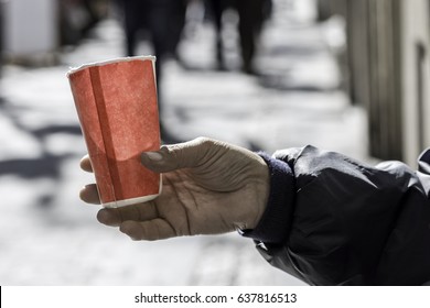 Poor Man Begging for Money on the Street Close Up. Dirty Beggar Hand Holding Paper Cup