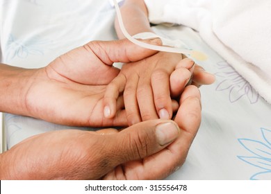 Poor Man Hand Holding Child's Hand,who Fever Patients Have IV Tube.