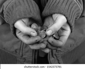 the poor man holds a handful of coins in black and white closeup