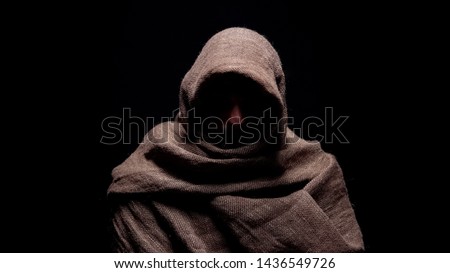 Poor man in rough robe looking down with humility, early christian prophet