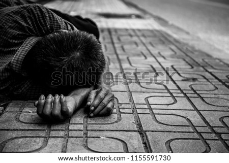 poor old man or beggar begging you for help sleeping sideroad at dirty slum. concept for poverty or hunger people,human Rights,donate and charity,background text.black and white tone.