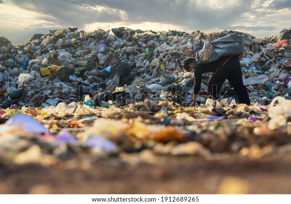 Poor people collect garbage for\
sale People living in garbage heaps walking to collect recyclable\
waste to be sold to poverty concept world environment\
day