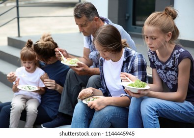 Poor People Eating Donated Food On Street